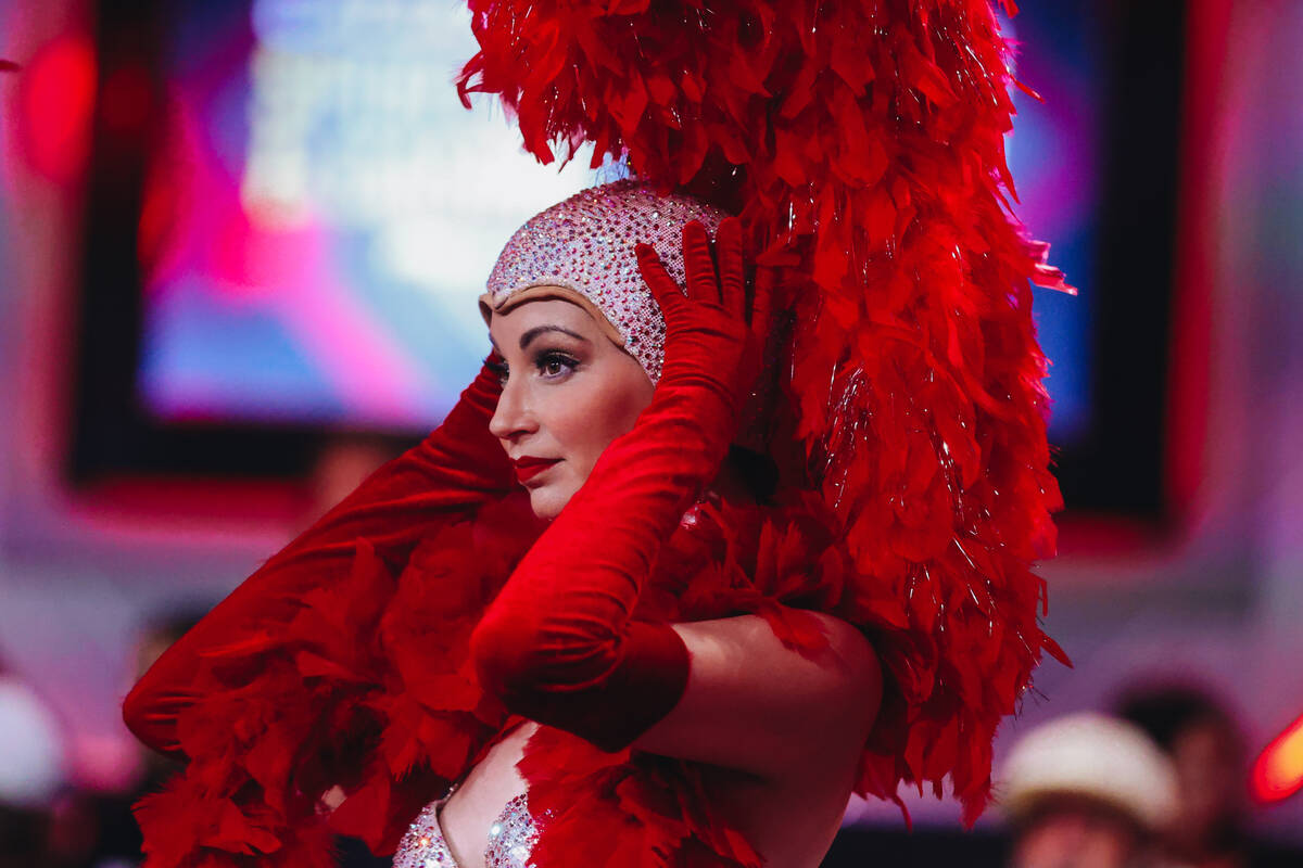 A showgirl adjusts her headpiece before going on air during the $10,000 buy-in No-limit Hold&#x ...