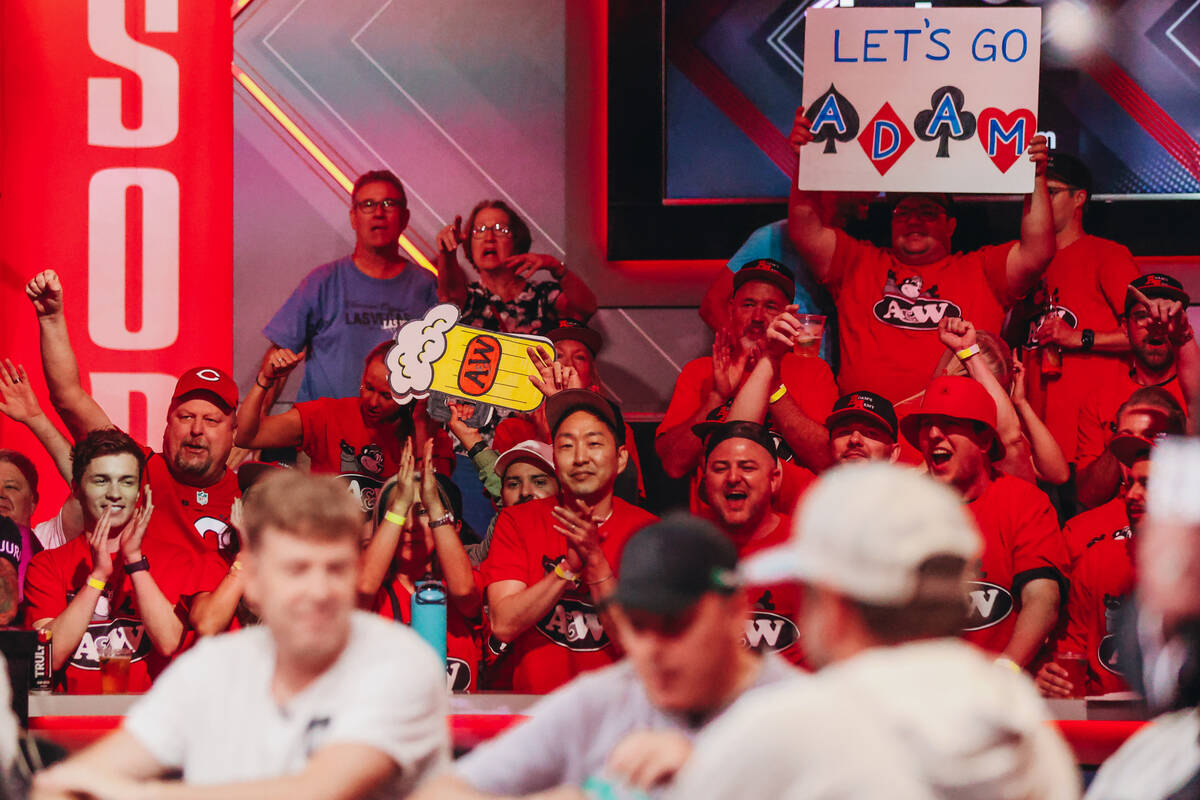Supporters of Adam Walton cheer and hold up signs during the $10,000 buy-in No-limit Holdȁ ...