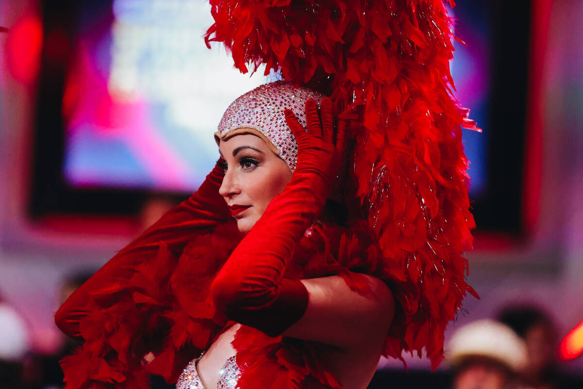 A showgirl adjusts her headpiece before going on air during the $10,000 buy-in No-limit Hold&#x ...