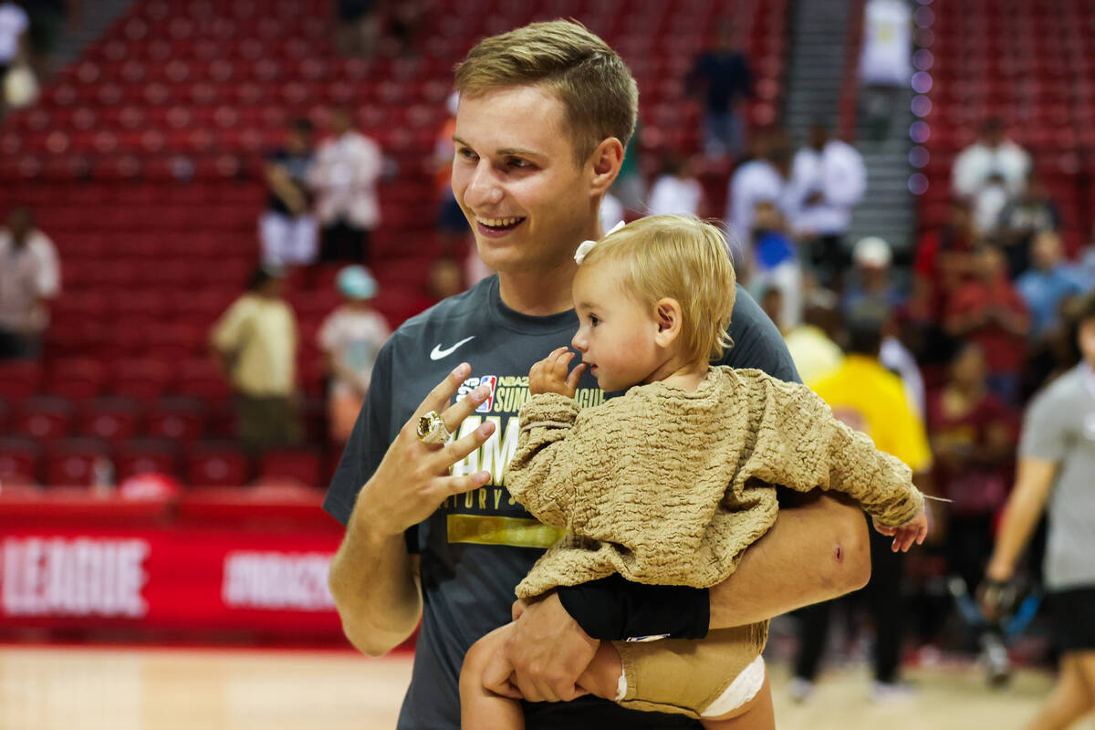 Cleveland Cavaliers guard Sam Merrill (5) shows off his new ring while holding his daughter Ken ...