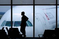 A passenger waits for a Delta Airlines flight at Hartsfield-Jackson International Airport in At ...