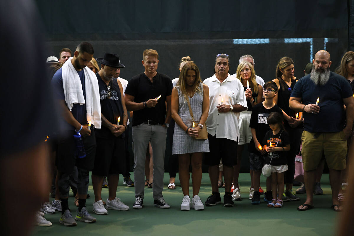 People hold candles during a candlelight vigil for Brandon Farber at the Lifetime Fitness tenni ...