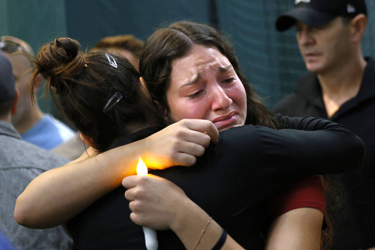 Brandon Farber’s sister Harley receives a hug during a candlelight vigil for Farber at the Li ...