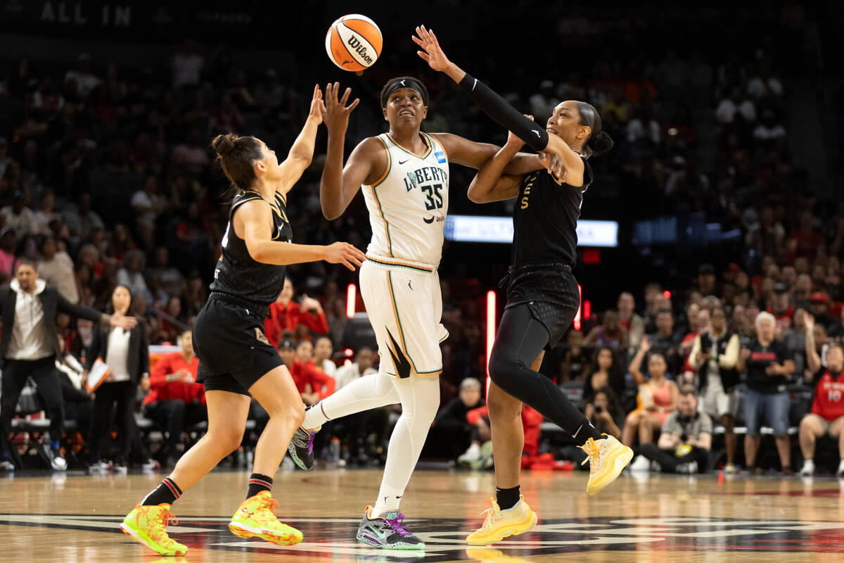 Las Vegas Aces guard Kelsey Plum, left, and forward A'ja Wilson, right, put pressure on New Yor ...