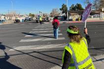 Crossing Guard Connie Walsh helps a student cross the street at Warren Elementary School in Las ...