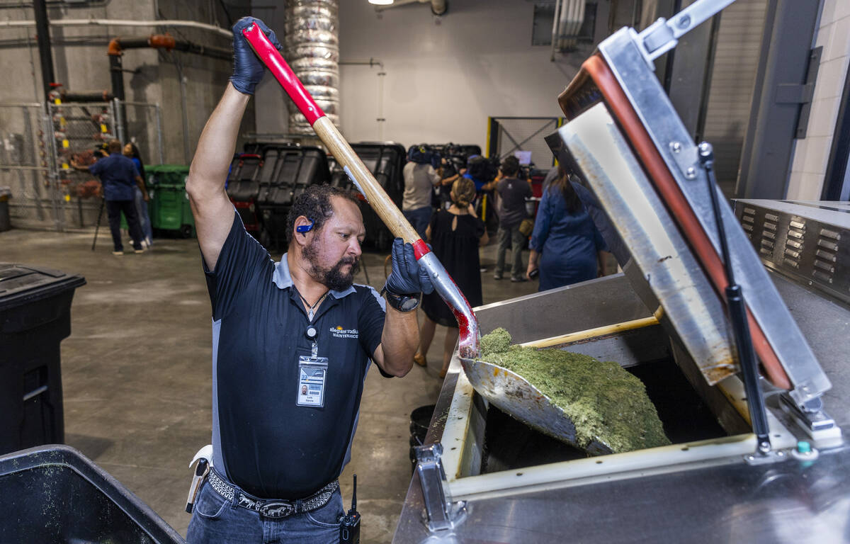 Allegiant Stadium team member Luis Garcia loads grass clippings into their composter which cont ...