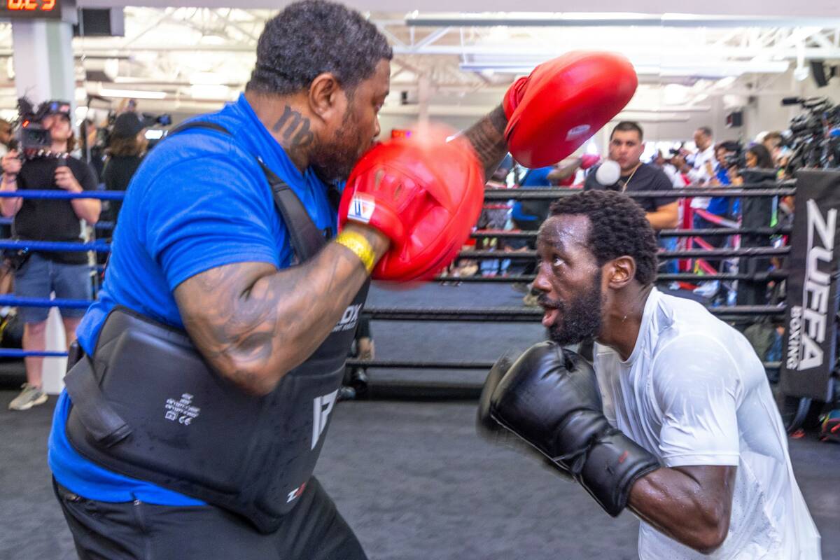 Terence Crawford ducks below the pads held by trainer Red Spike at the UFC Apex gym on Wednesda ...