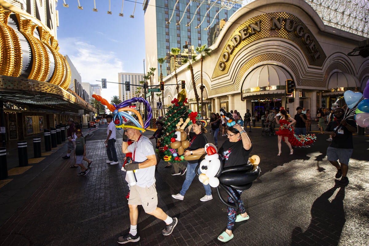 Attendees of the Bling Bling Jam balloon convention participate in a parade along the Fremont S ...