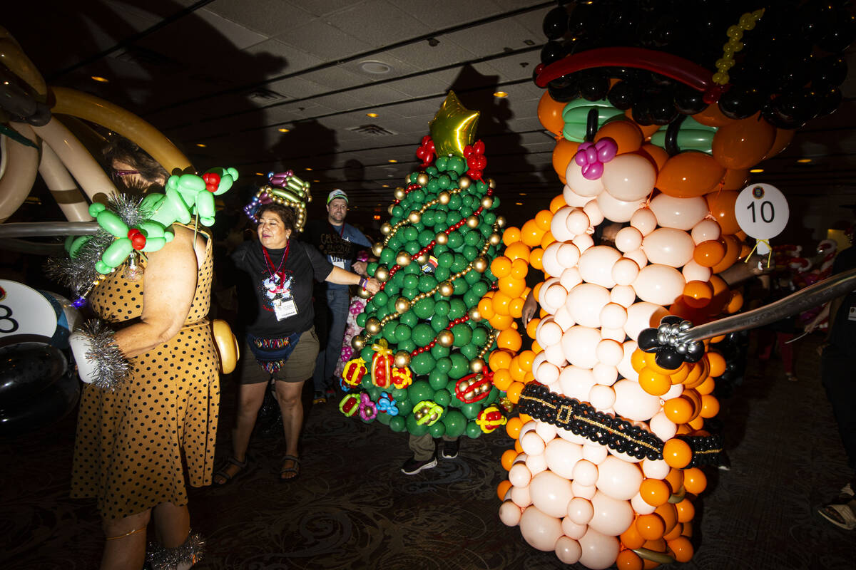 Attendees of the Bling Bling Jam balloon convention walk through Binion’s before a parad ...