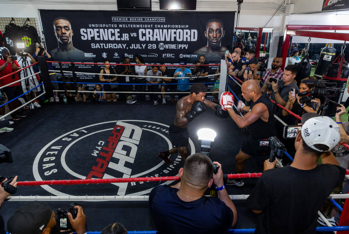 Fighter Errol Spence Jr. hits the pads with trainer Derrick James during a media workout day at ...