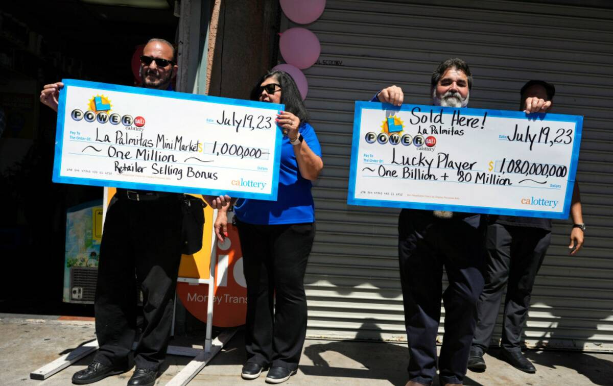 California State Lottery officials hold up enlarged checks during a news conference outside the ...