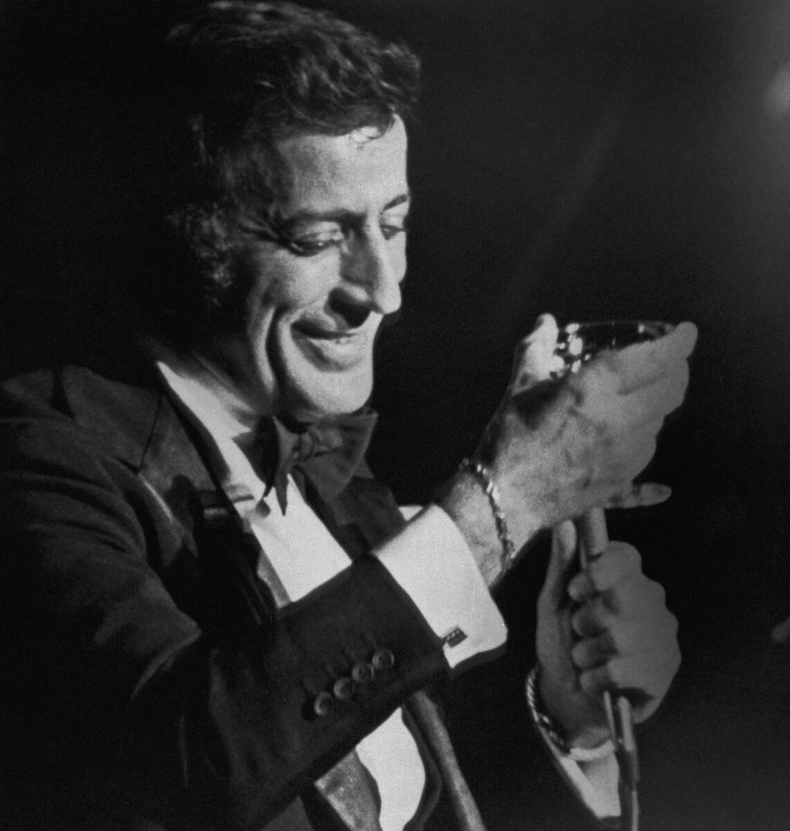 Singer Tony Bennett toasts his audience with campaign during a engagement April 10, 1977 at the ...