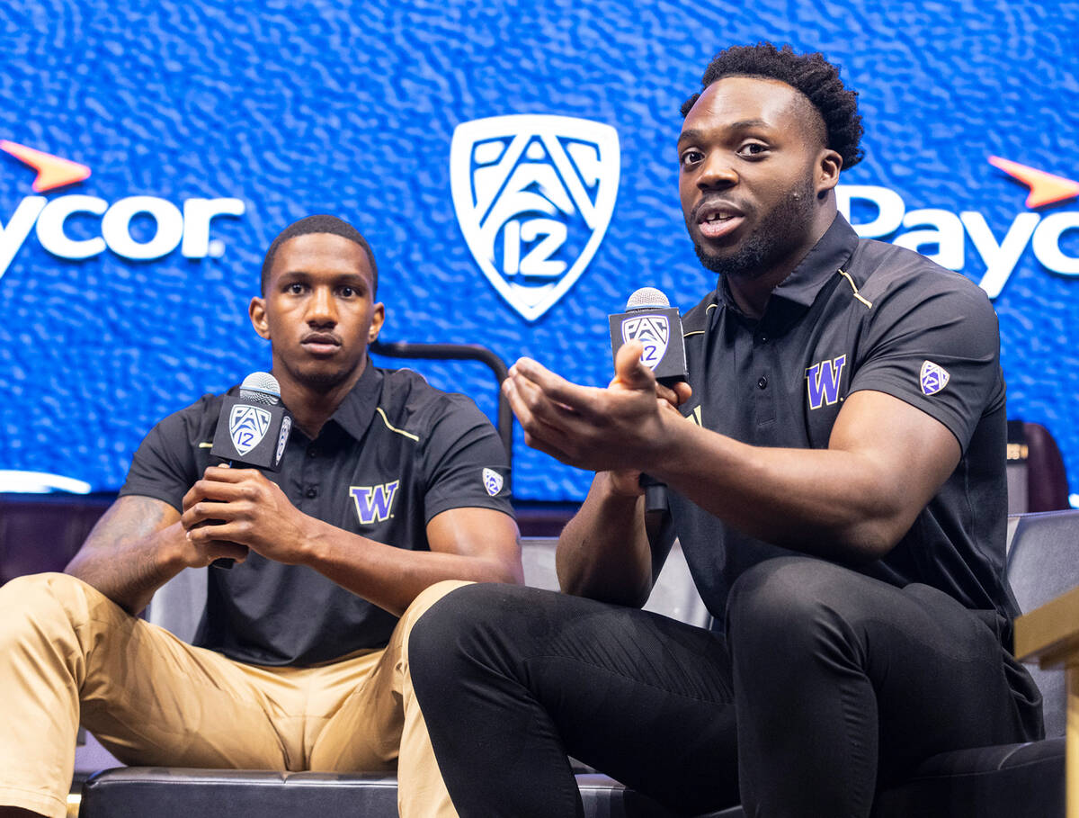 Washington Huskies quarterback Michael Penix Jr., left, listens as linebacker Edefuan Ulofoshio ...