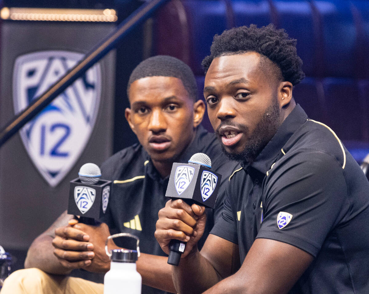 Washington Huskies quarterback Michael Penix Jr., left, listens as linebacker Edefuan Ulofoshio ...