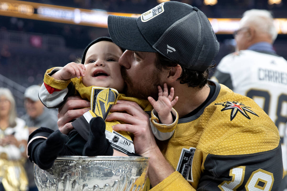 Golden Knights right wing Reilly Smith kisses his daughter Isla, sitting in the Stanley Cup, af ...