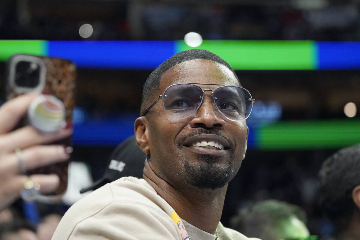 FILE - Jamie Foxx smiles during an NBA basketball game between the Washington Wizards and Dall ...