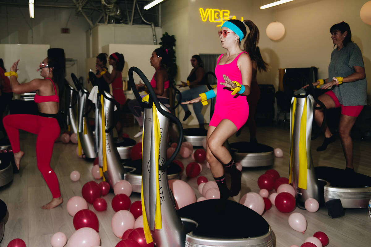 A workout class, including Kelsey Kapman, front, participates in a Barbie themed cardio dance s ...