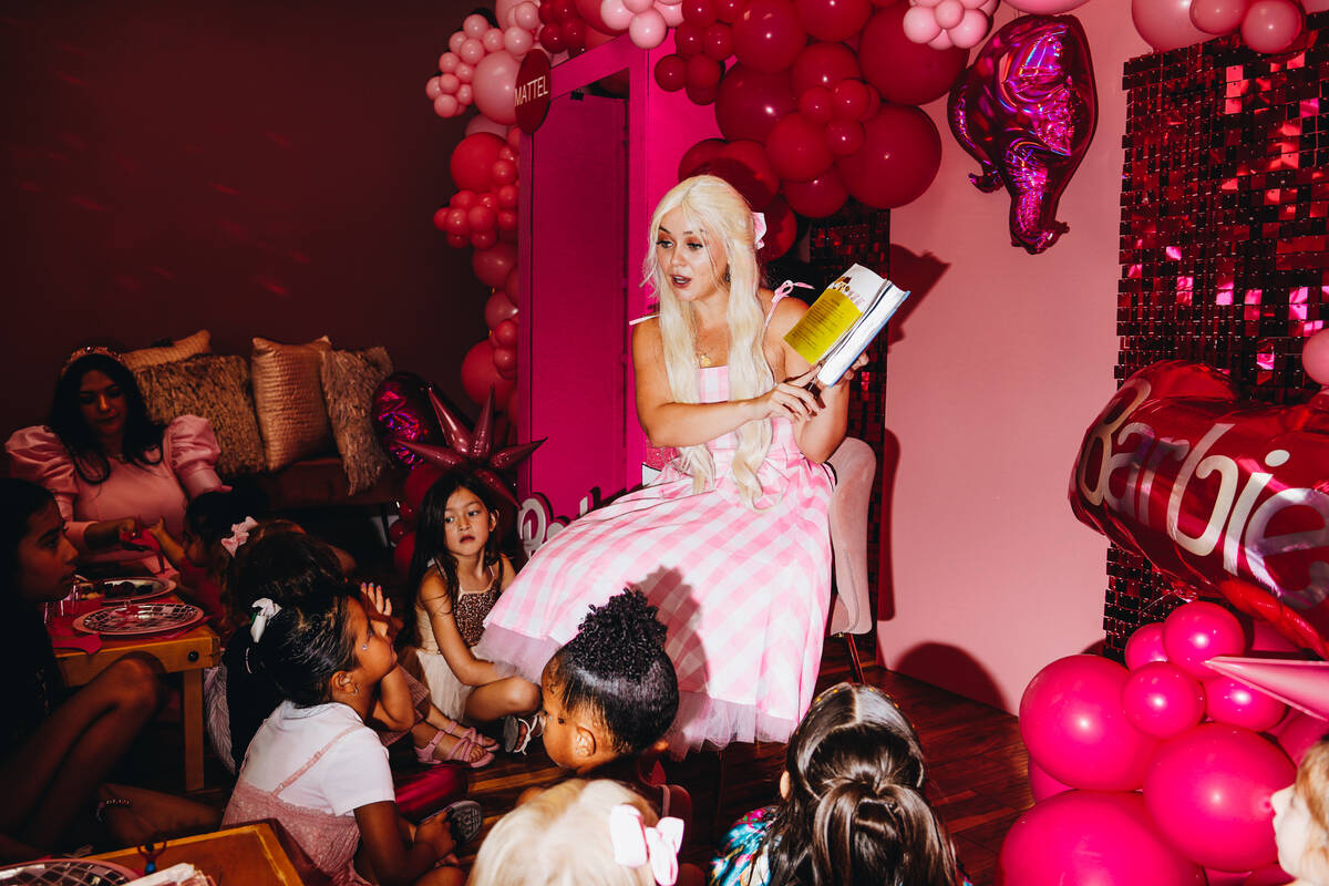 Barbie reads “The Three Little Pigs” to a group of young girls at a Barbie themed ...