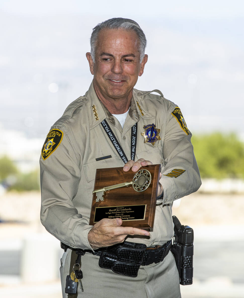 Sheriff Joe Lombardo shows off the plaque he just received during a ribbon-cutting and unveilin ...