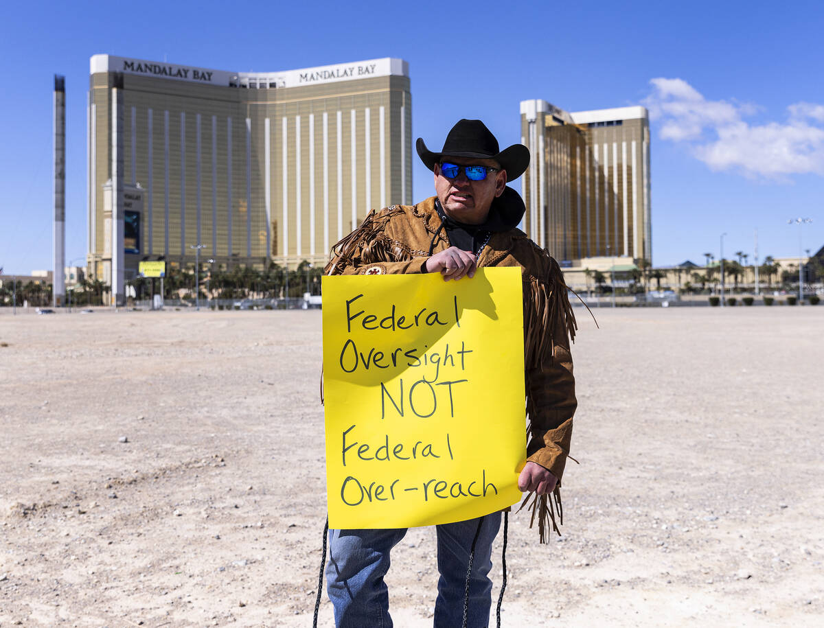 Todd Hall, a member of North Dakota's Mandan, Hidatsa and Arikara Nation (MHA), holds a sign as ...