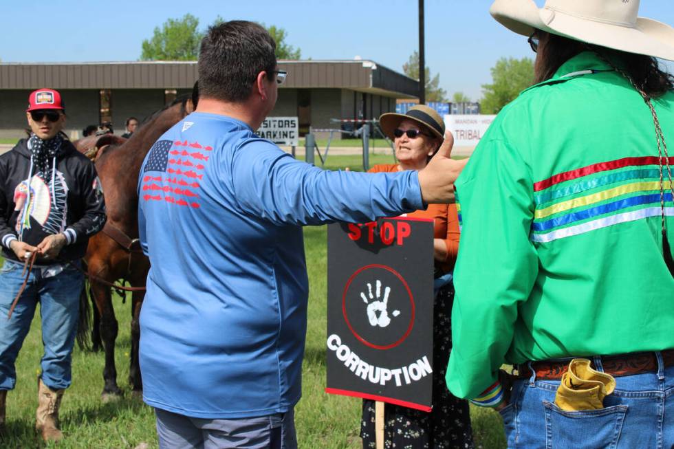 MHA Nation tribal council member Robert White, in blue shirt, speaks with Becky Beaks and other ...