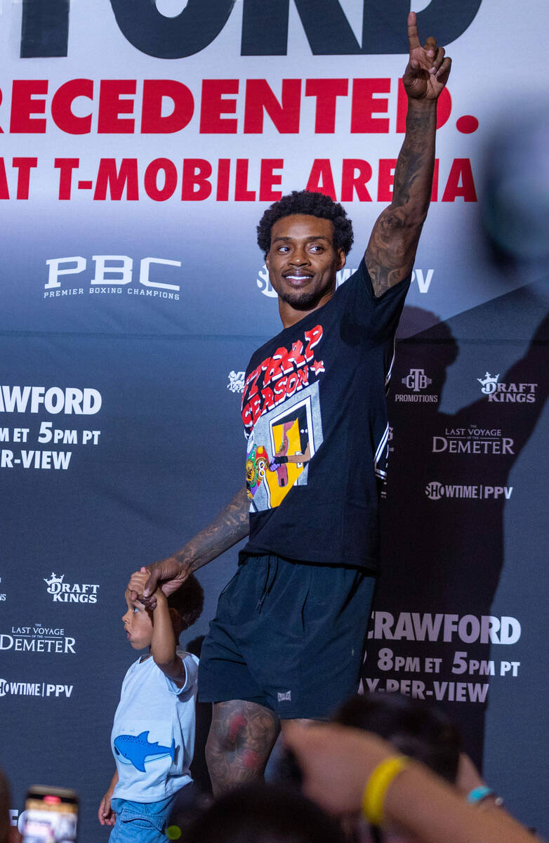 Welterweight boxer Errol Spence Jr., signals to fans as he walks in with his son Dallas during ...