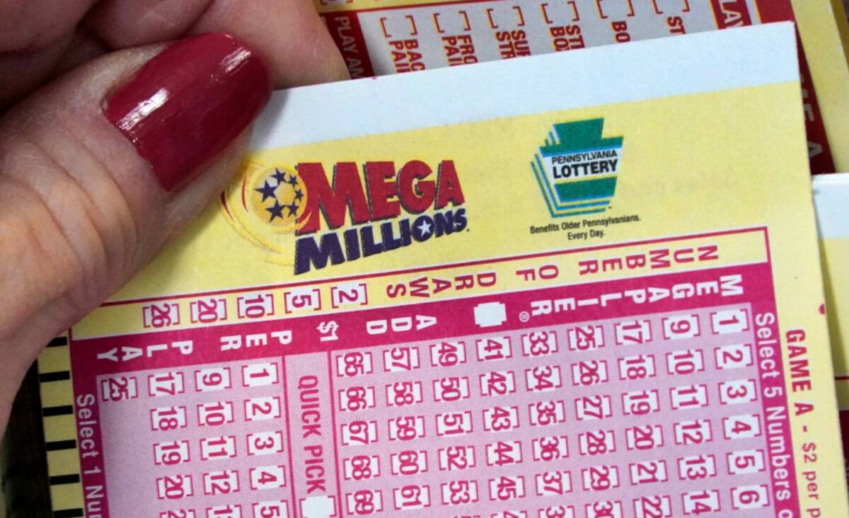 A Mega Millions wagering slip is held in Cranberry Township, Pa., Jan. 12, 2023. (AP Photo/Gene ...