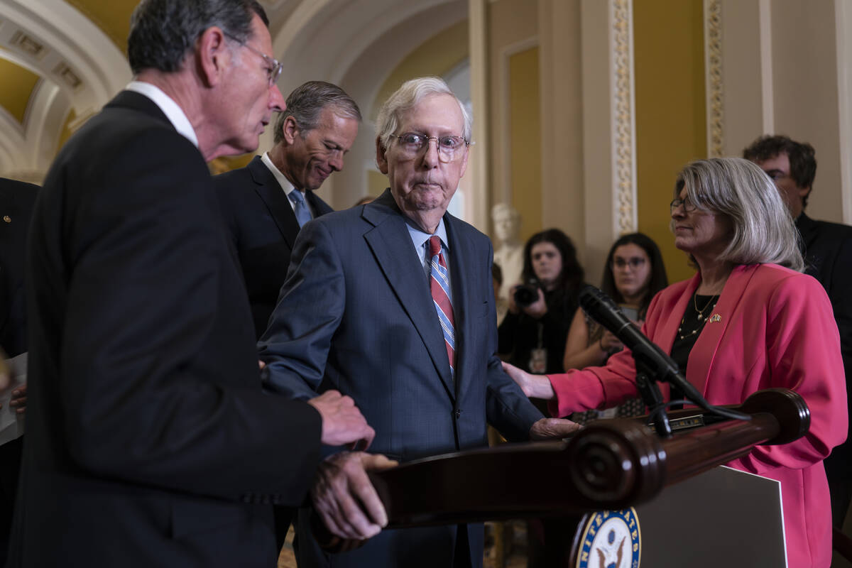 Senate Minority Leader Mitch McConnell, R-Ky., center, is helped by, from left, Sen. John Barra ...