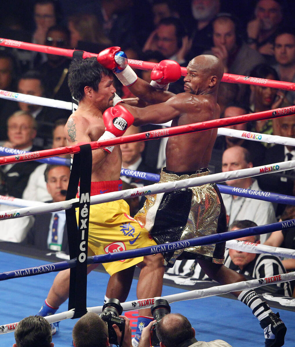 Manny Pacquiao, left, and Floyd Mayweather Jr. mix it up in the second round of their welterwei ...