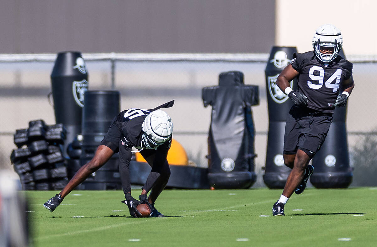 Raiders DE Chandler Jones (55) picks up a fumble beside DT Matthew Butler (94) during training ...