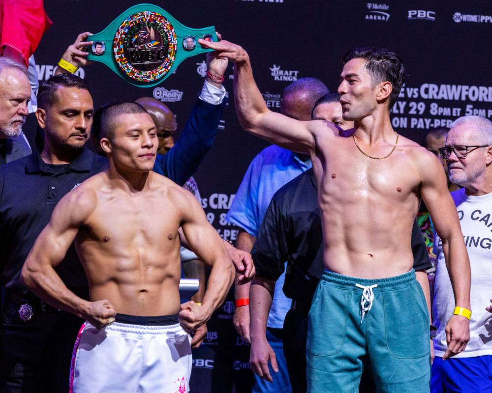 Boxer Isaac Cruz flexes as his opponent Giovanni Cabrera jokes about his height following their ...