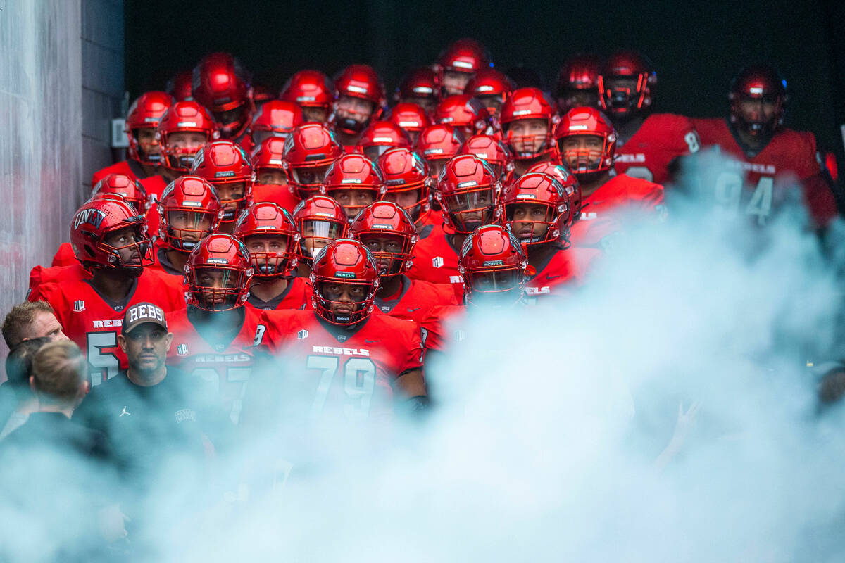 FILE - UNLV Rebels head coach Marcus Arroyo and players await to be introduced behind smoke bef ...