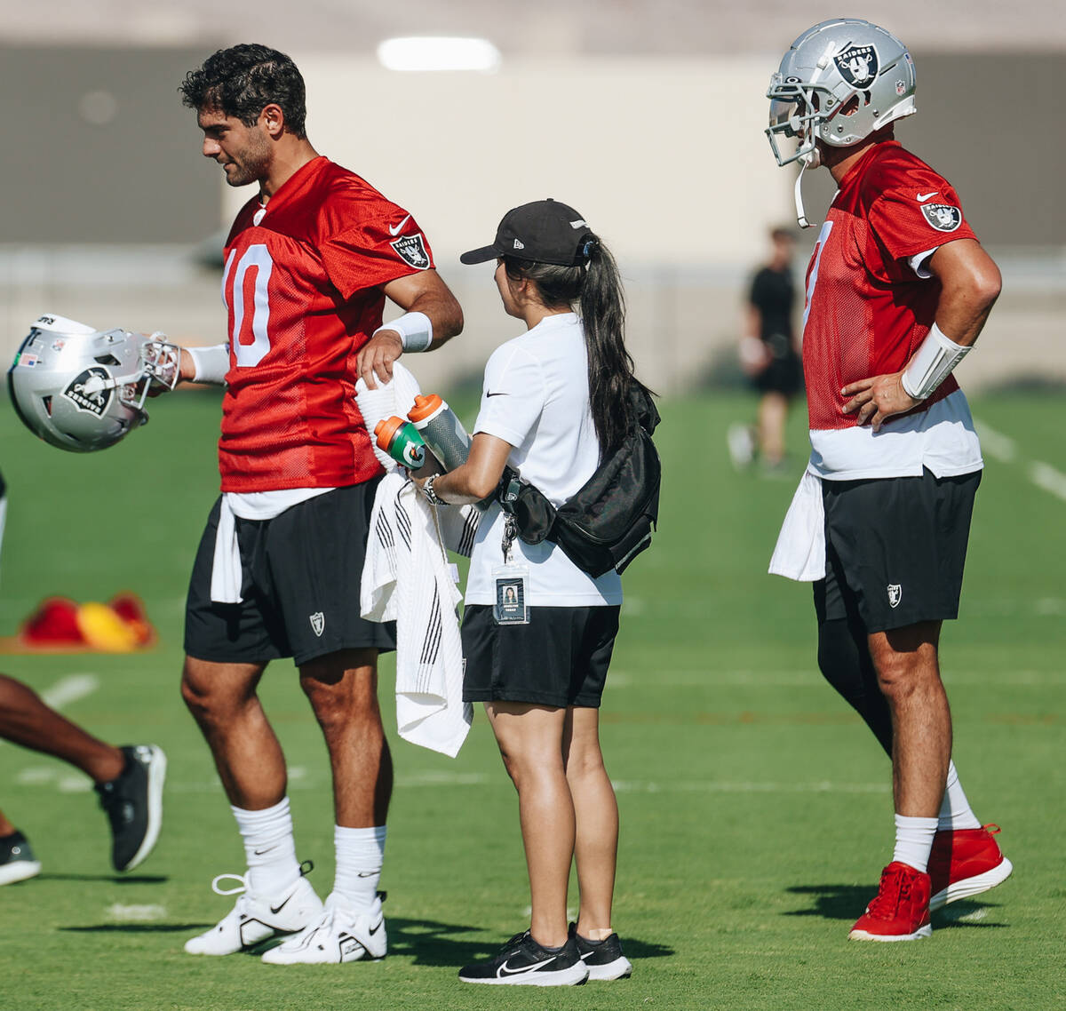 Raiders quarterback Jimmy Garoppolo (7) grabs a towel while fellow quarterback Brian Hoyer gets ...