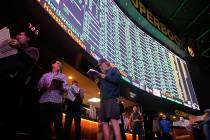 Sports bettors line up as the menu of Super Bowl props is on display at the Westgate SuperBook, ...