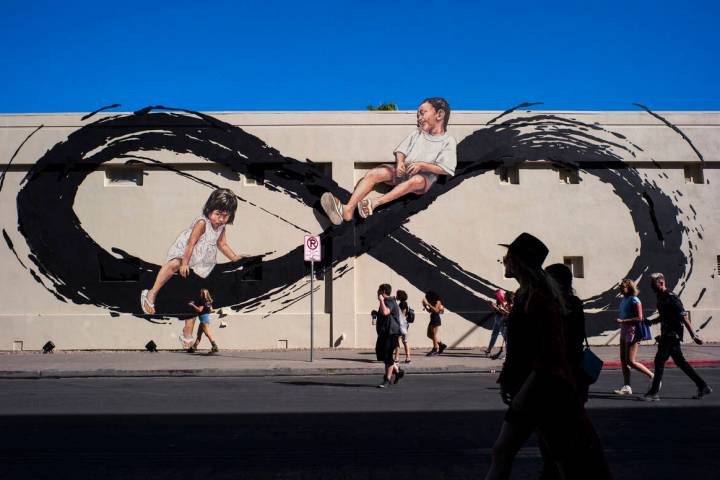 Attendees pass by a mural by Ernest Zacharevic during day 2 of the Life is Beautiful festival i ...