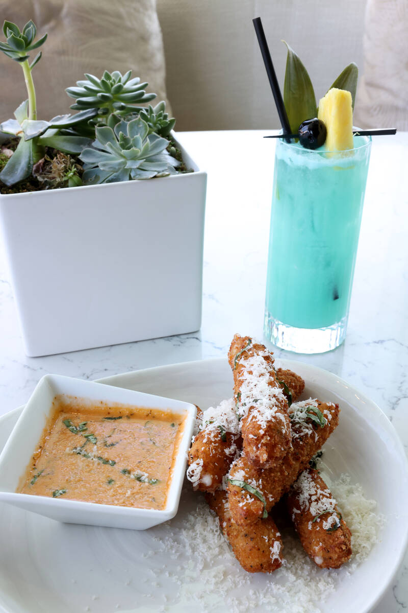 Provolone Fritto appetizer and Laguna Blue signature cocktail are shown at Laguna Pool House &a ...