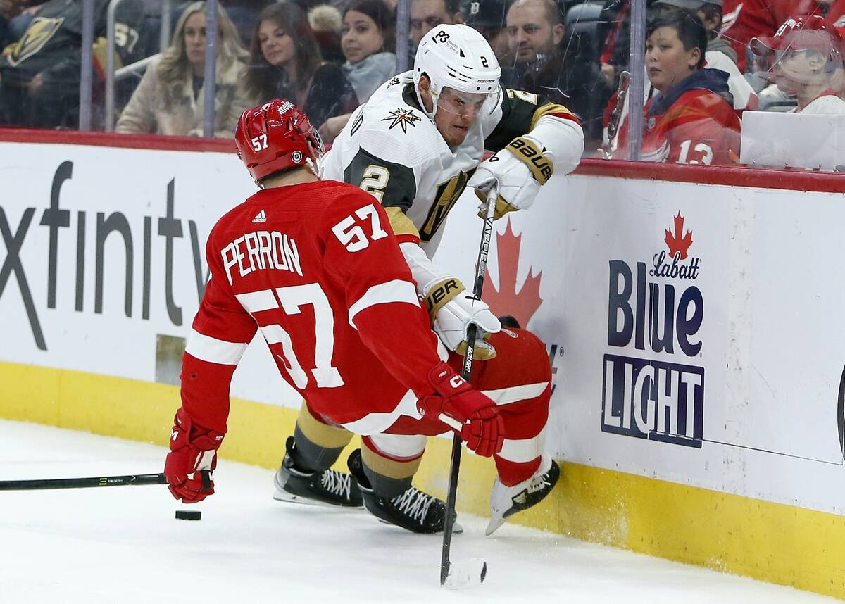 Vegas Golden Knights defenseman Zach Whitecloud (2) knocks over Detroit Red Wings left wing Dav ...