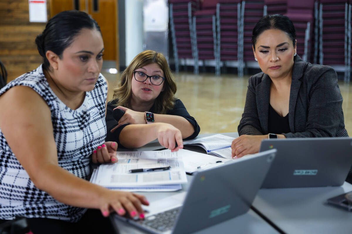 Sarah Swallia, an instructor with Curriculum Associates, helps new hires Blanca Lopez, left, an ...
