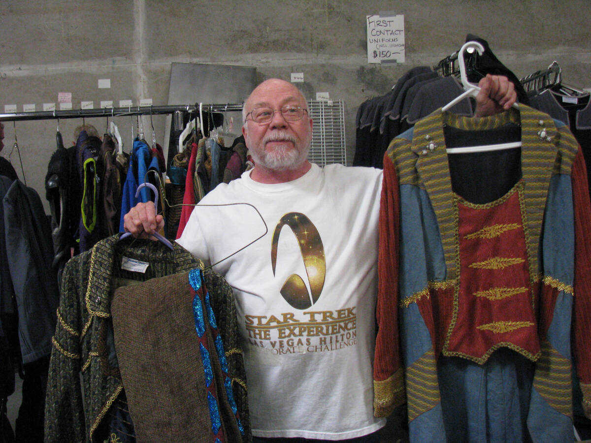 Richard Oden, who portrayed the Ferengi Rog'l at "Star Trek: The Experience" holds up costumes ...