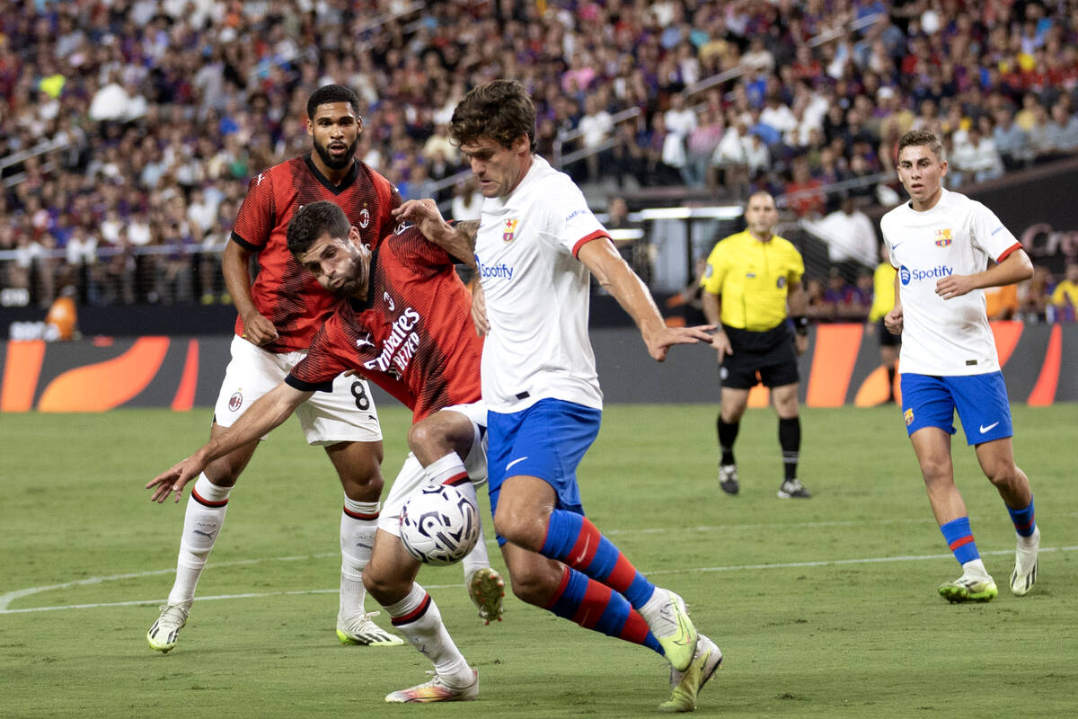 Milan forward Christian Pulisic, center left, defends against Barcelona defender Marcos Alonso, ...