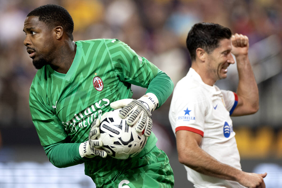 Milan goalkeeper Mike Maignan (16) saves a shot by Barcelona forward Robert Lewandowski, right, ...