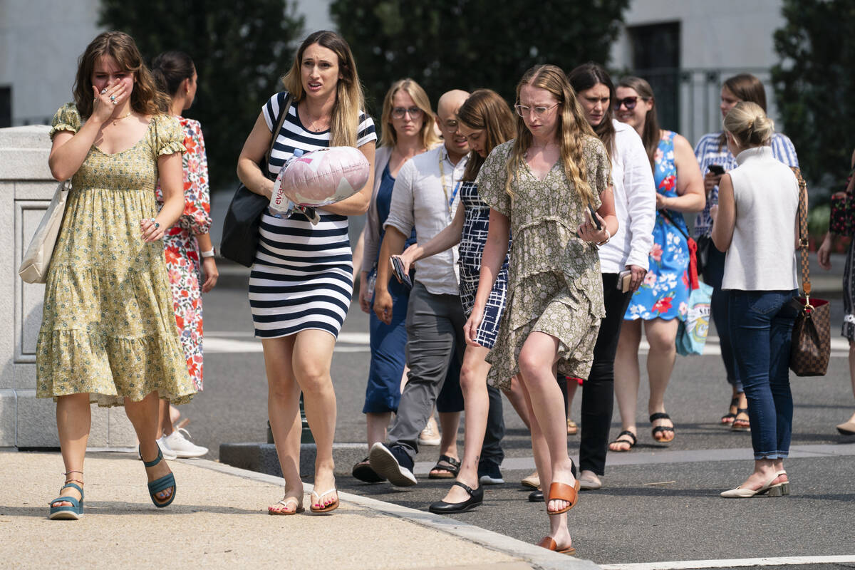 Government staffers walk out of the Russell Senate Office Building on Wednesday, Aug. 2, 2023, ...