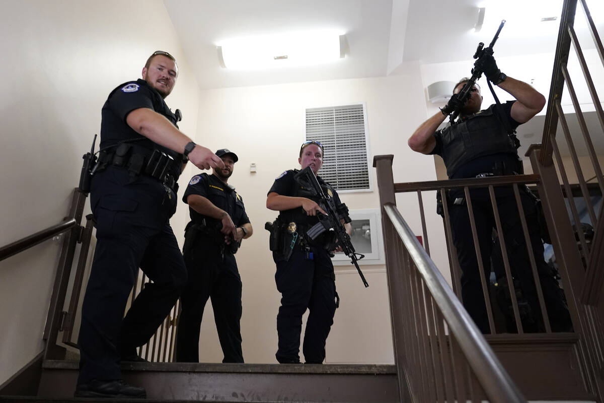 U.S. Capitol Police officers clear a stairwell in the Dirksen Senate Office Building next to th ...