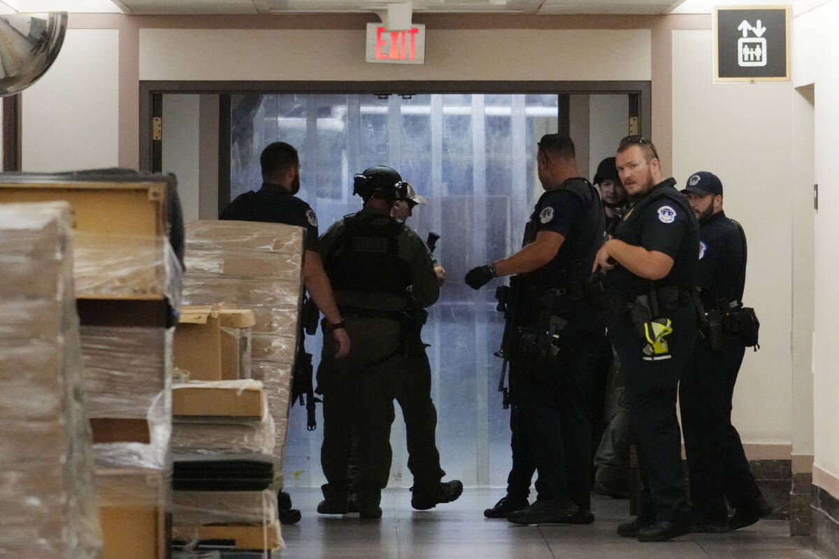 U.S. Capitol Police officers search an area in the basement of the Dirksen Senate Office Buildi ...