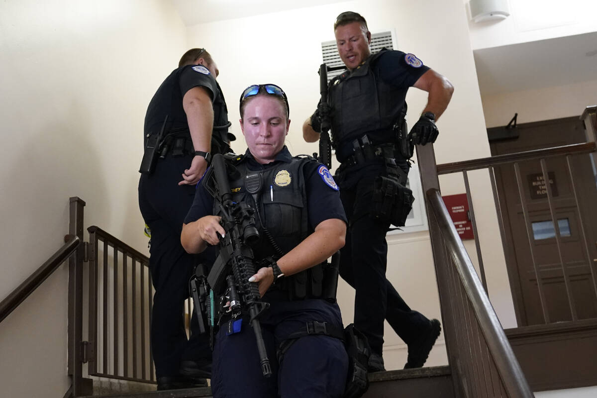 U.S. Capitol Police officers clear a stairwell in the Dirksen Senate Office Building next to th ...