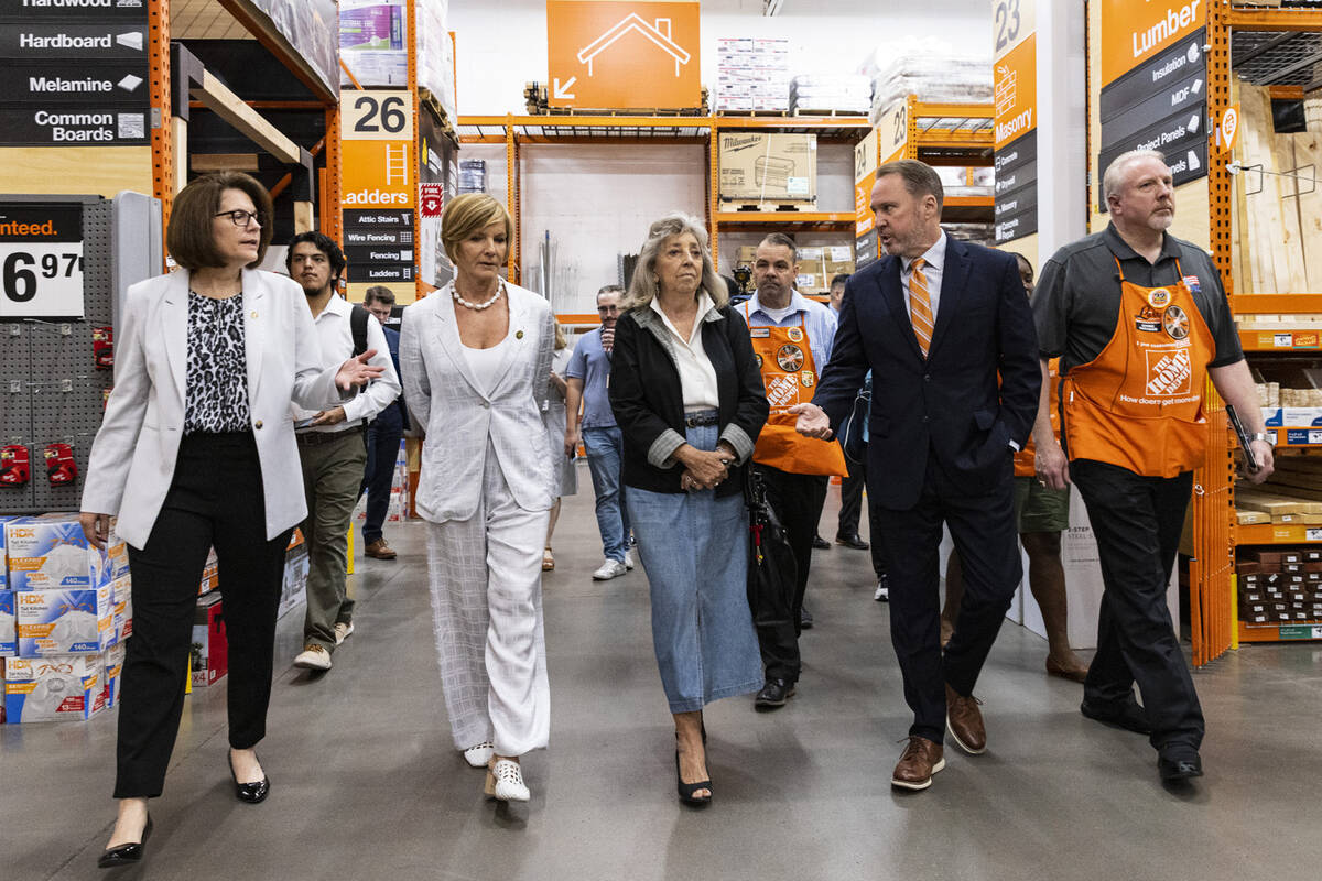 Scott Glenn, vice president of asset protection at Home Depot, second right, leads a tour of th ...