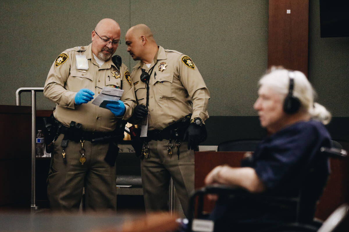 Officers speak to each other while Thomas Randolph listens to his court hearing at the Regional ...