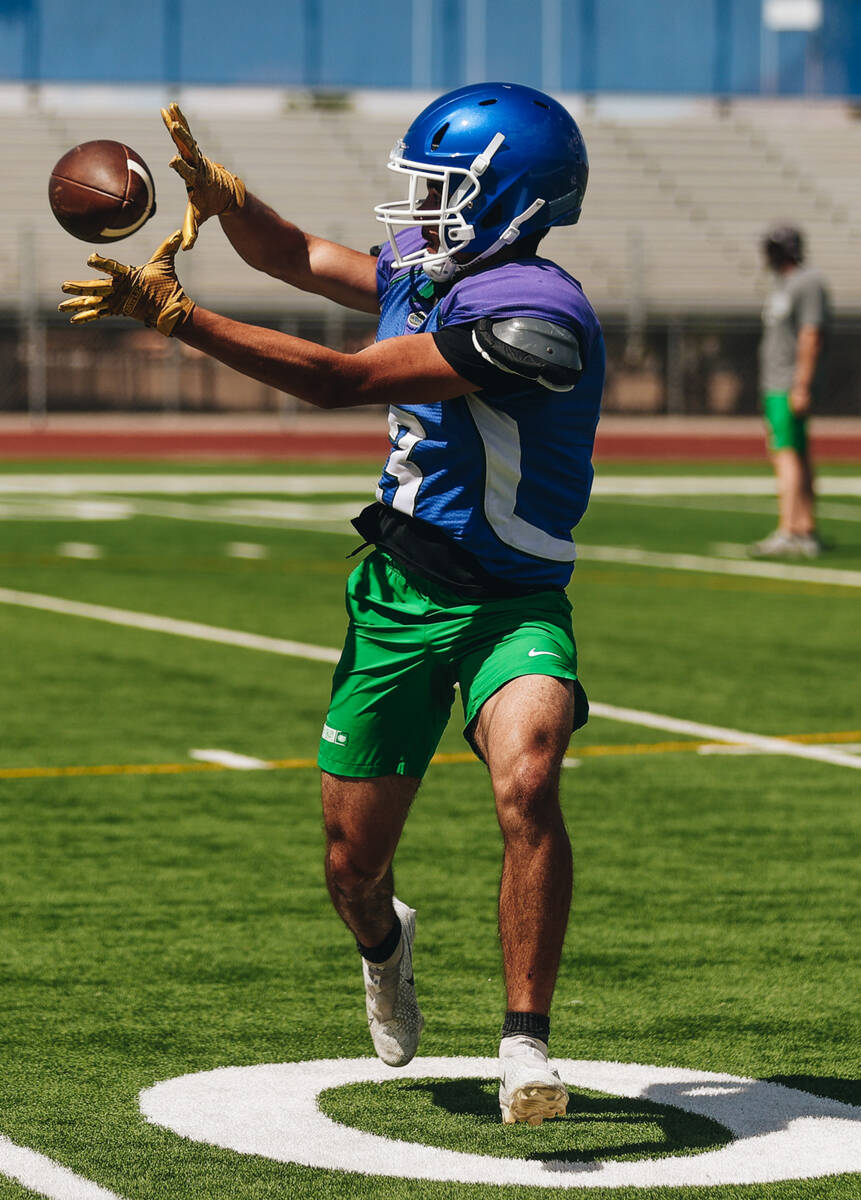 A Green Valley football player catches the ball during a drill at practice at Green Valley High ...
