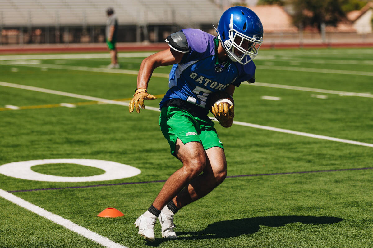 A Green Valley football player runs with the ball during a drill at practice at Green Valley Hi ...