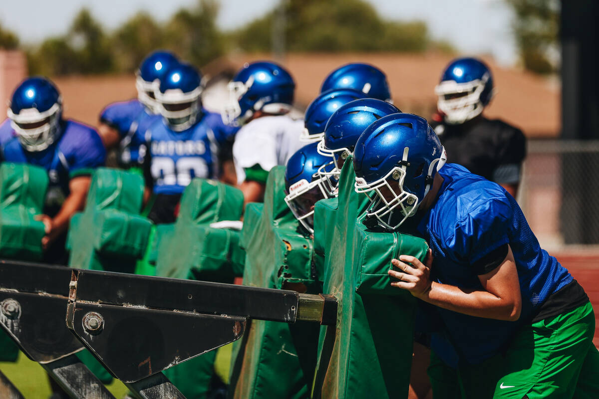 Green Valley football players run through a drill with a blocking sled during practice at Green ...